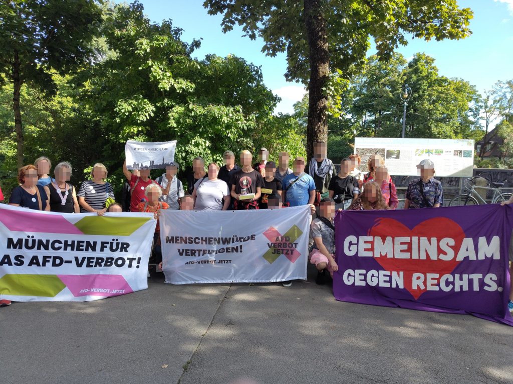 Teilnehmer*innen der antifaschistischen Stadtfürung am Endpunkt vor der Maximiliansbrücke, mit Transpis von AfD-Verbot-Jetzt und Gemeinsam gegen Rechts